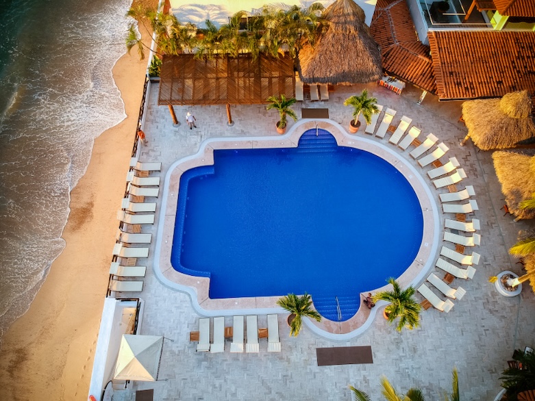 Aerial view of a pool to the right of the ocean